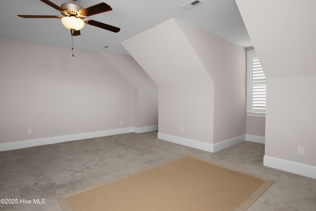 additional living space featuring lofted ceiling, carpet flooring, a ceiling fan, and visible vents