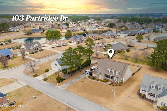 aerial view at dusk featuring a residential view