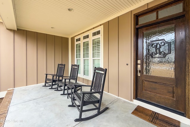 doorway to property featuring board and batten siding and covered porch