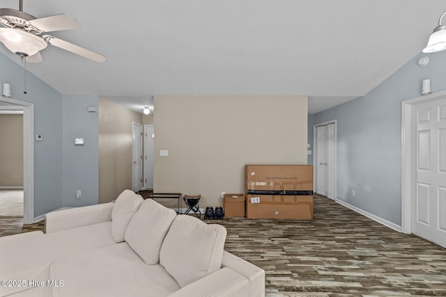 living room featuring ceiling fan, dark hardwood / wood-style flooring, and vaulted ceiling