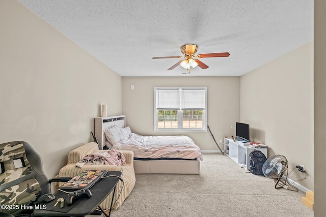 bedroom featuring ceiling fan, light carpet, and a textured ceiling