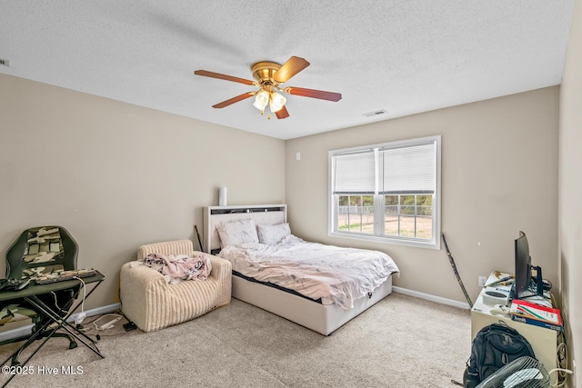 carpeted bedroom featuring ceiling fan and a textured ceiling