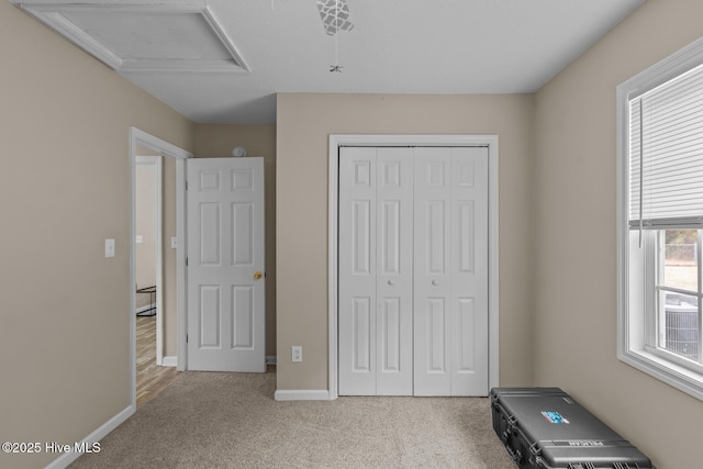 unfurnished bedroom featuring light carpet and a closet