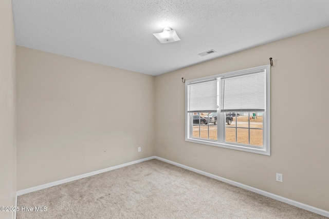 carpeted empty room featuring a textured ceiling