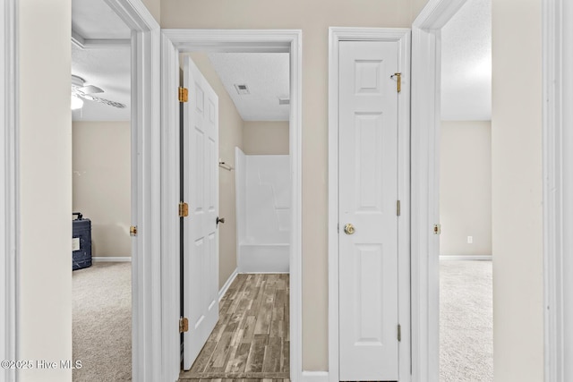 corridor with carpet flooring and a textured ceiling