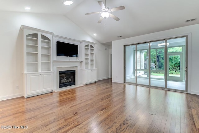 2173 Palm Pointe NE, Leland, NC 28451 - unfurnished living room with light wood-style floors, ceiling fan, lofted ceiling, a fireplace with raised hearth, and baseboards