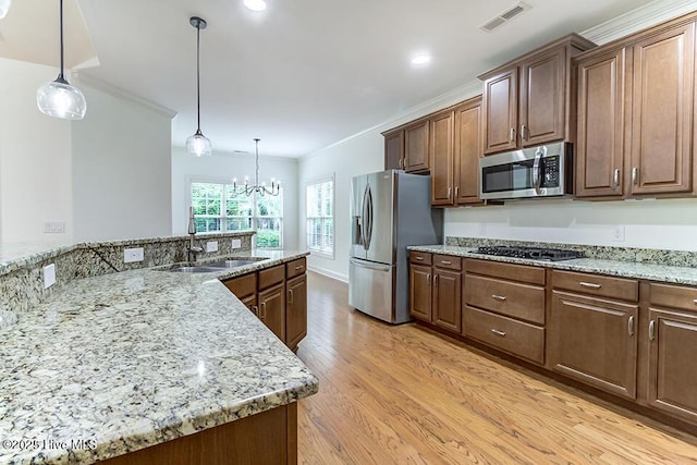 2173 Palm Pointe NE, Leland, NC 28451 - kitchen featuring appliances with stainless steel finishes, a sink, light wood-style floors, ornamental molding, and a chandelier