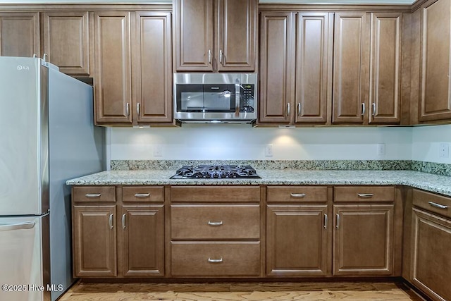 2173 Palm Pointe NE, Leland, NC 28451 - kitchen with appliances with stainless steel finishes, light wood-type flooring, and light stone counters