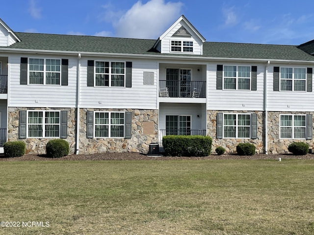 view of front of property with central AC unit and a front lawn