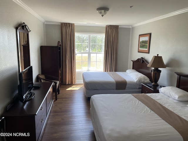 bedroom with ornamental molding and dark hardwood / wood-style flooring