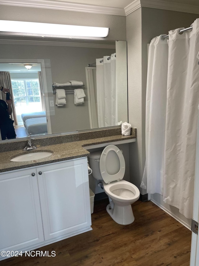 full bathroom with shower / tub combo, vanity, wood-type flooring, ornamental molding, and toilet