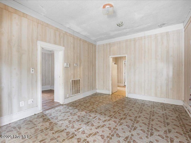 spare room with ornamental molding and a textured ceiling