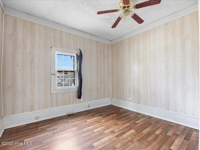 spare room with ornamental molding, dark hardwood / wood-style floors, ceiling fan, and a textured ceiling