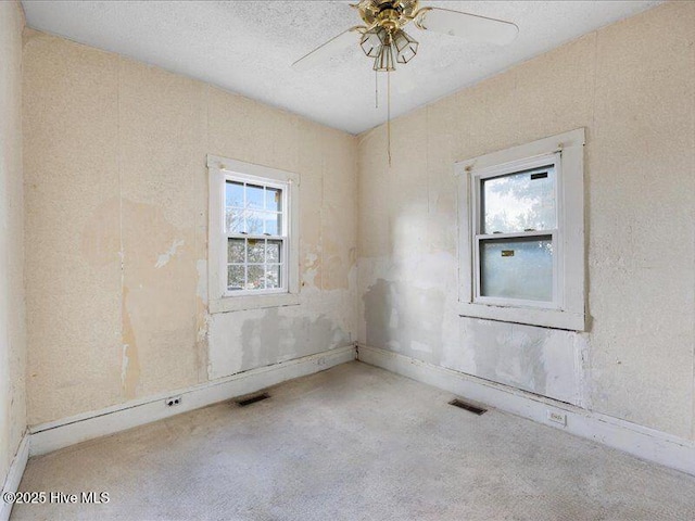 unfurnished room featuring ceiling fan, carpet flooring, and a textured ceiling