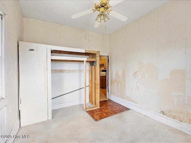 unfurnished bedroom featuring ceiling fan, a closet, and light parquet floors