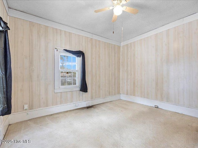 carpeted spare room featuring ceiling fan, crown molding, and a textured ceiling