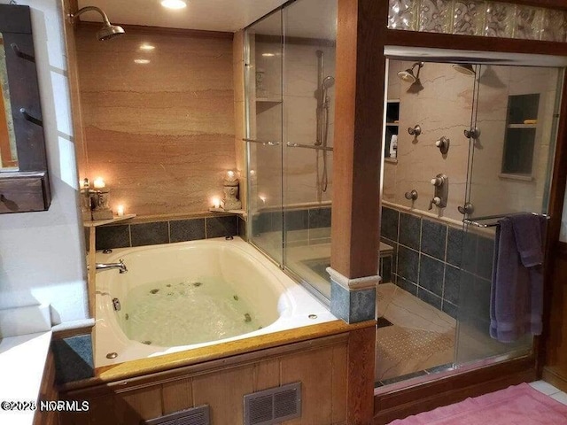 bathroom featuring shower with separate bathtub and tile walls