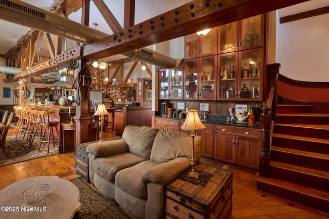 living room featuring wood-type flooring and bar