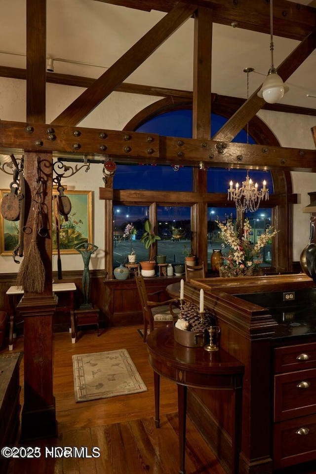 interior space featuring lofted ceiling with beams, hardwood / wood-style floors, and a chandelier