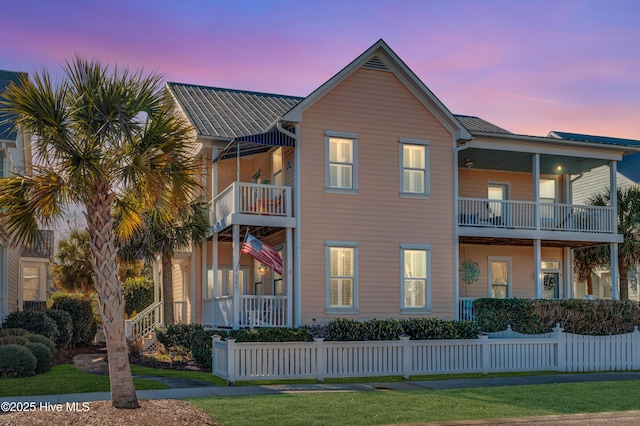 view of front of home with a lawn and a balcony