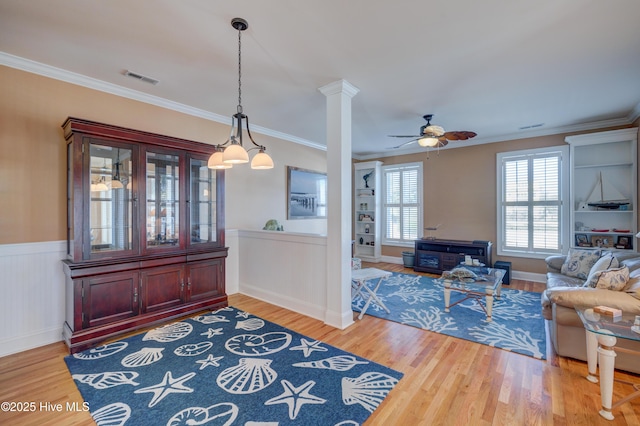 interior space with hardwood / wood-style floors, crown molding, decorative columns, and ceiling fan