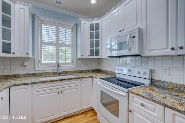 kitchen with white cabinetry, white appliances, stone countertops, and sink