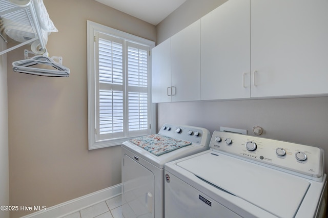 washroom featuring cabinets, light tile patterned floors, independent washer and dryer, and a healthy amount of sunlight