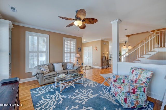 living room featuring crown molding, ceiling fan, light hardwood / wood-style floors, and decorative columns