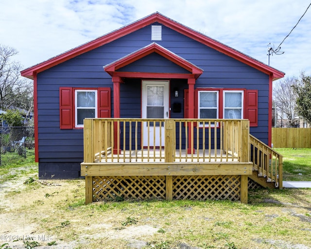 view of front of house with a deck and fence