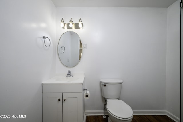 bathroom with hardwood / wood-style flooring, vanity, and toilet