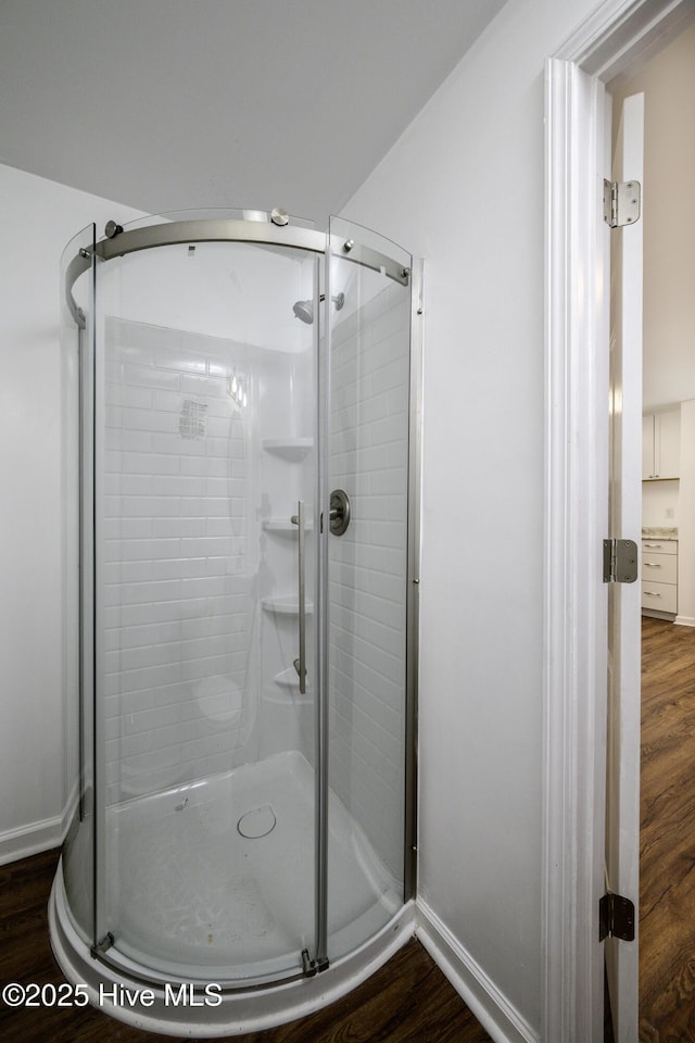 bathroom featuring an enclosed shower and wood-type flooring