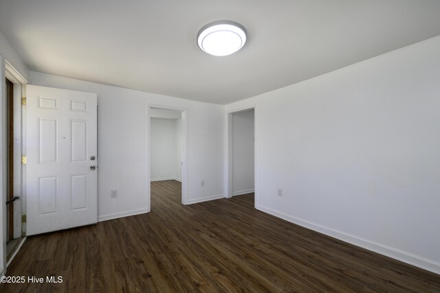 unfurnished room with dark hardwood / wood-style flooring