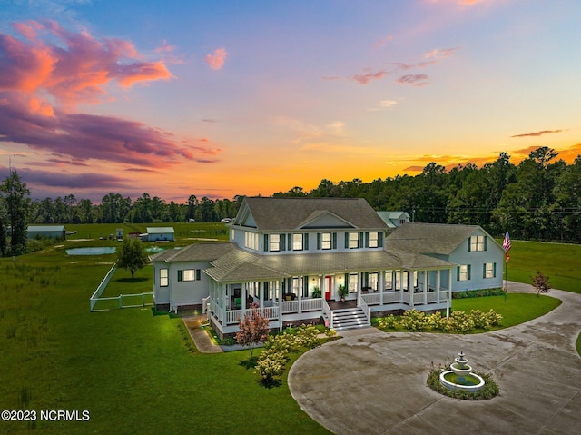 country-style home with covered porch and a lawn