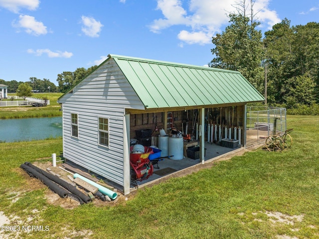 view of outdoor structure featuring a water view and a yard