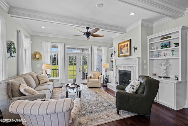 living room featuring crown molding, a fireplace, dark hardwood / wood-style flooring, and french doors