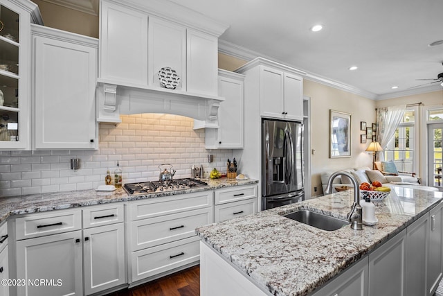 kitchen with a kitchen island with sink, sink, white cabinets, and appliances with stainless steel finishes