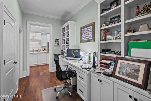 office with dark hardwood / wood-style flooring, crown molding, and built in desk