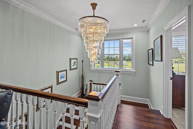 stairs with an inviting chandelier, ornamental molding, and hardwood / wood-style floors