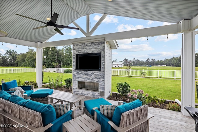 view of patio featuring an outdoor living space with a fireplace and ceiling fan