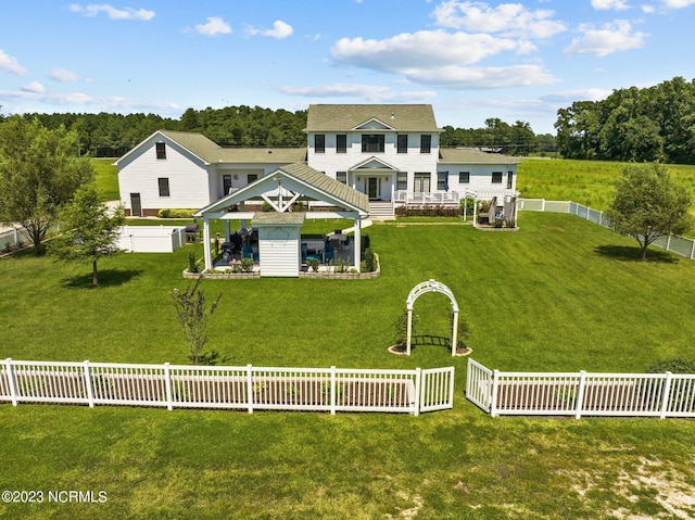 rear view of property featuring a gazebo and a yard