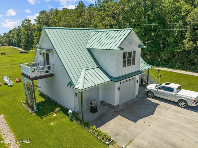 exterior space featuring a garage, a lawn, and a balcony