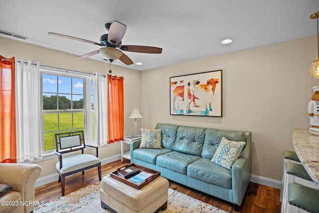 living room featuring ceiling fan and dark hardwood / wood-style flooring