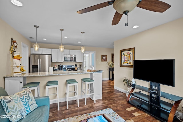 living room with dark wood-type flooring and ceiling fan