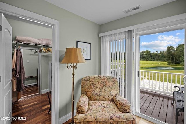 sitting room with a water view and dark hardwood / wood-style floors