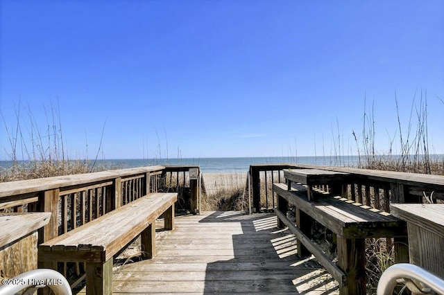 dock area with a water view and a beach view