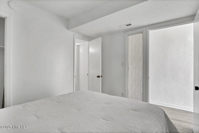 unfurnished bedroom featuring a textured ceiling and light wood-type flooring