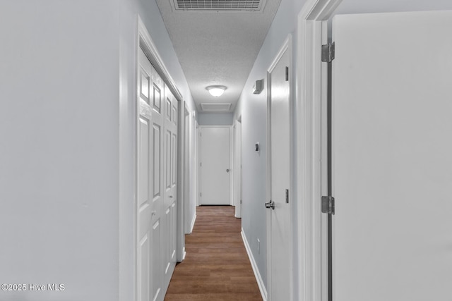 hall with dark hardwood / wood-style floors and a textured ceiling