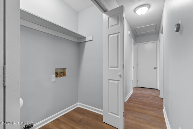 laundry room with wood-type flooring, washer hookup, and a textured ceiling