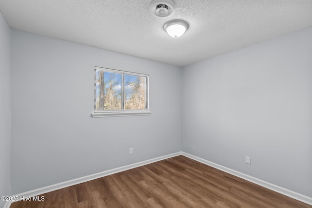 spare room with wood-type flooring and a textured ceiling