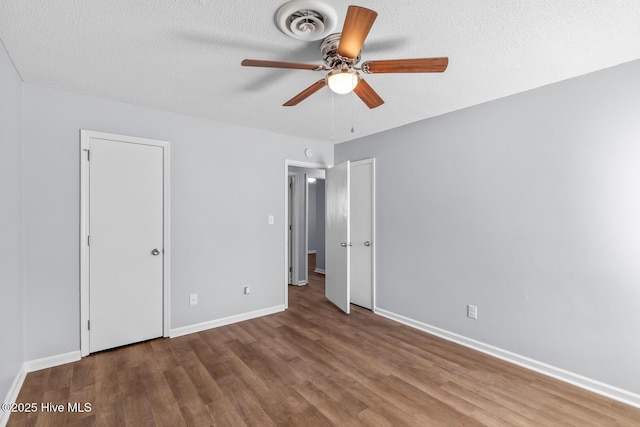 unfurnished bedroom featuring ceiling fan, wood-type flooring, and a textured ceiling